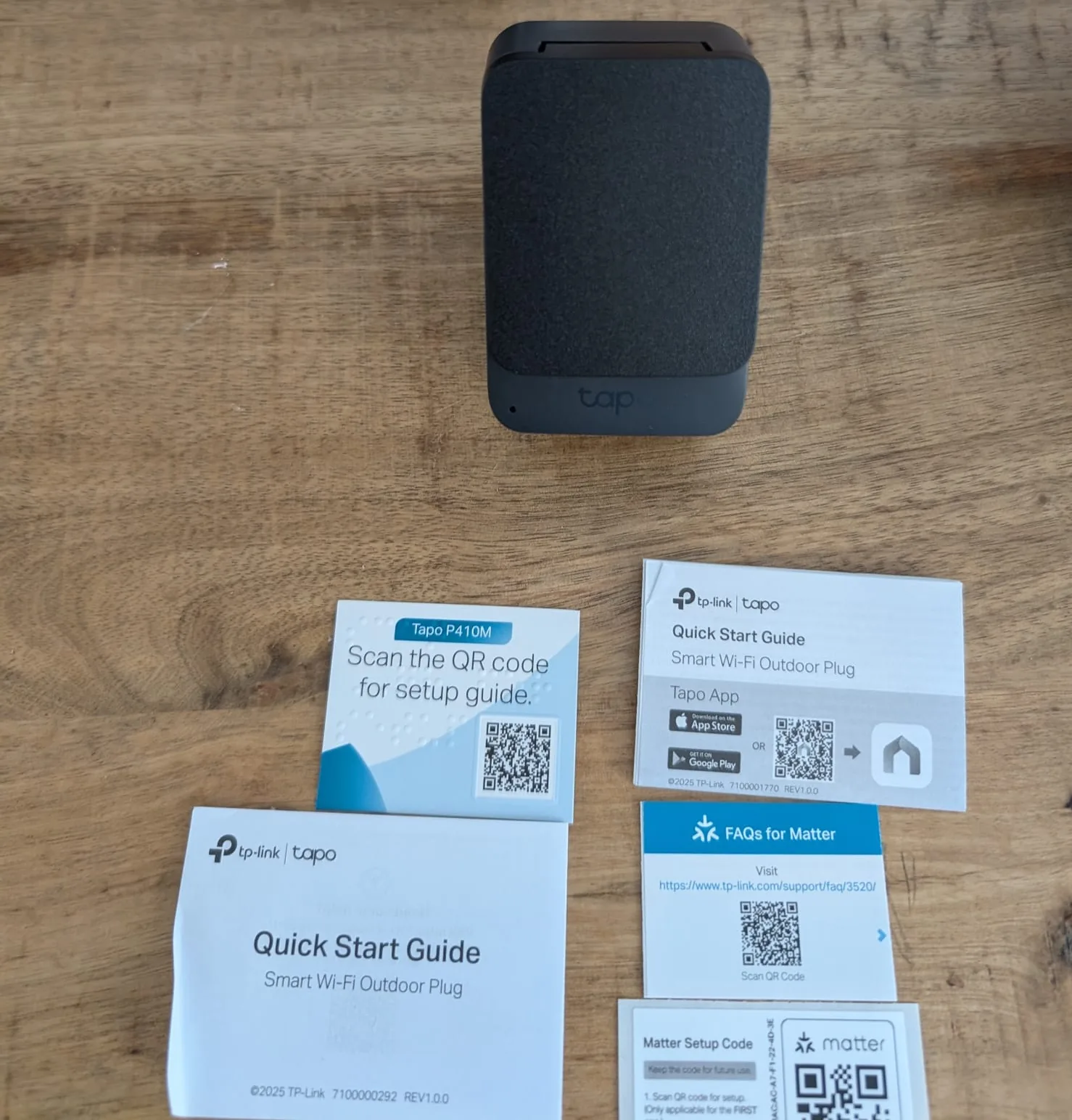 Tapo P410M uitgevouwen op tafel met Matter code kaartje en Quick Start Guide